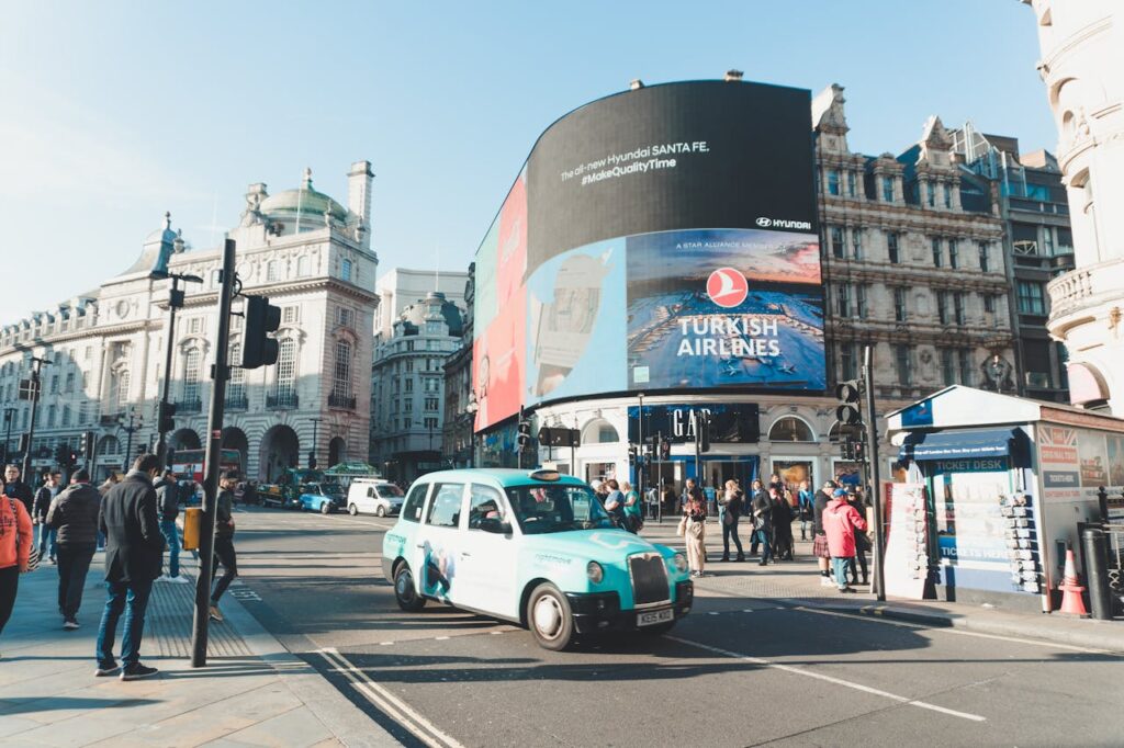 Bustling Piccadilly Circus in London featuring iconic taxis and vibrant city life.